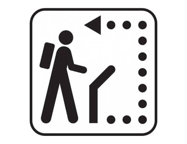 Icon of a person with a backpack looking at a sign or map.