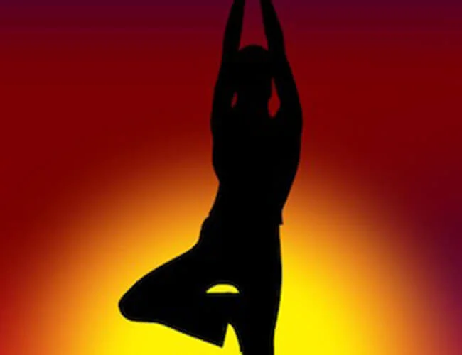 Person doing a yoga pose at sunset.