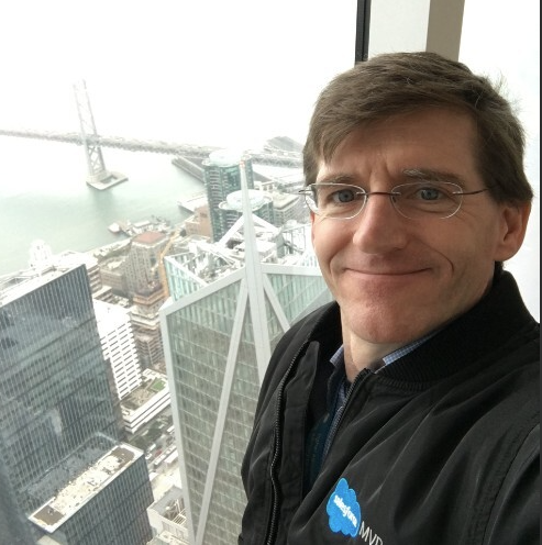 professional male smiling with a cityscape behind him