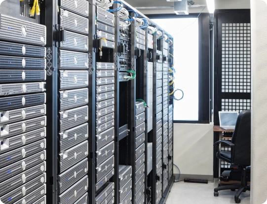 Rows of server racks in a data center with network cables and equipment