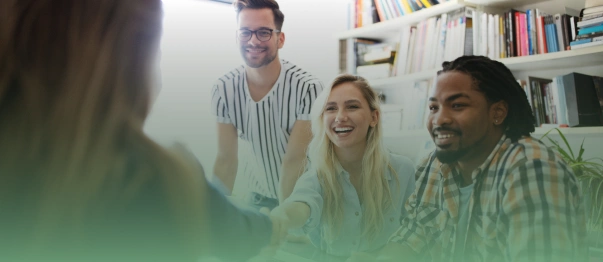 Group of people smiling and shaking hands during a meeting in an office