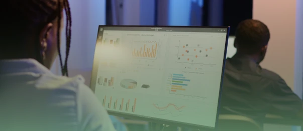Professional viewing charts and analytics on a computer monitor in an office
