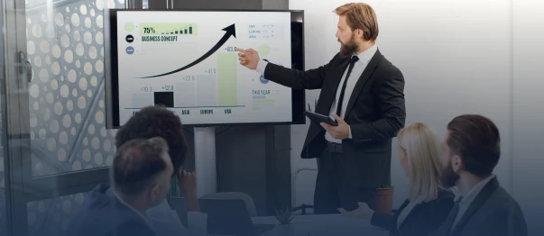Presenter explaining a growth chart to a business team in a meeting room