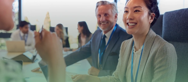 Business professionals smiling during a meeting in a conference room