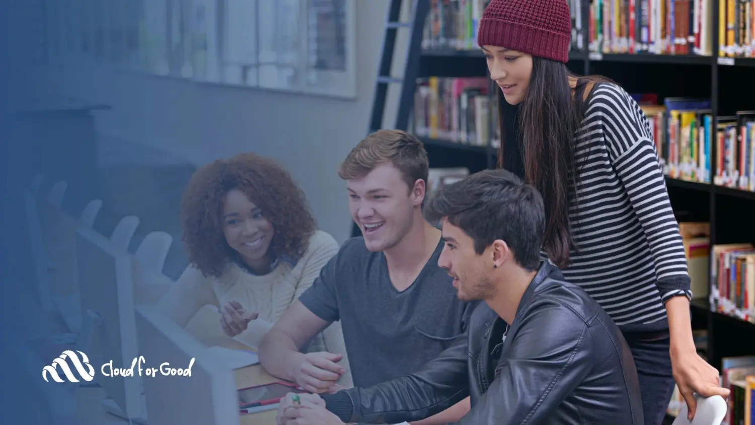Diverse students collaborating at computer in college library - Cloud for Good