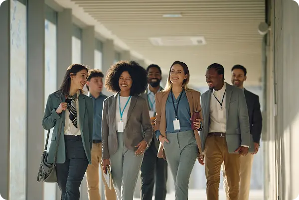 Diverse group of professionals walking together through a modern office corridor